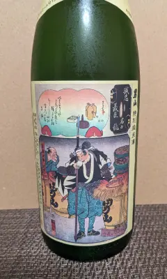 男山 特別純米酒 大辛口 国芳乃名取酒のラベル。男山の樽、酒を口に運ぶ義士
